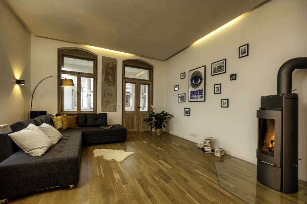 Offenes Wohnzimmer mit Stehlampe, Sofa, Kamin und Bildern in Ferienwohnung in Dresden